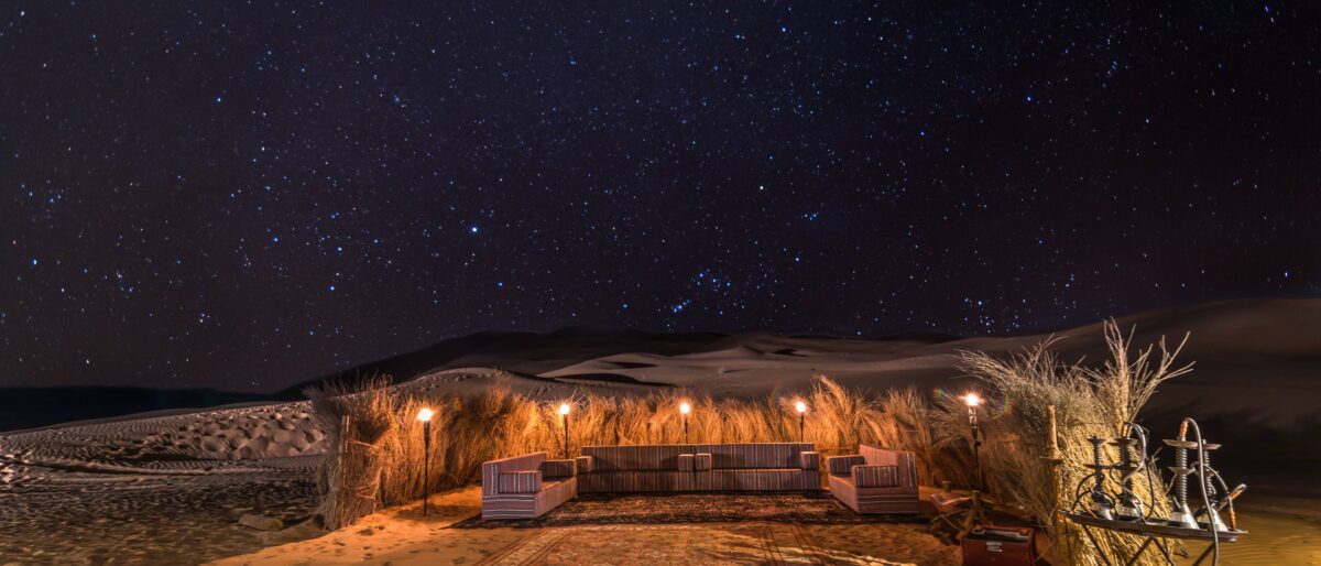 4x4 tracks across golden sand dunes of Wahiba Sands leading towards the Indian Ocean