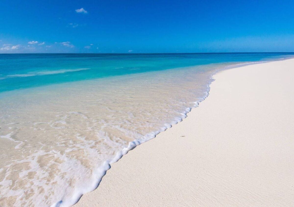 Aerial view of Mahé island coastline with lush green hills, white beaches and clear blue ocean