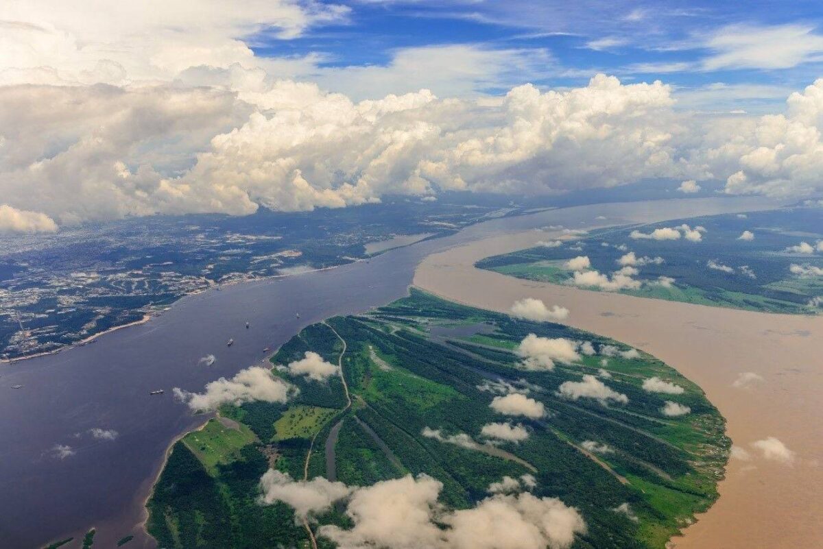 Aerial view of Manaus with the port, jungle-fringed riverbanks and colorful buildings stretching along the Amazon River
