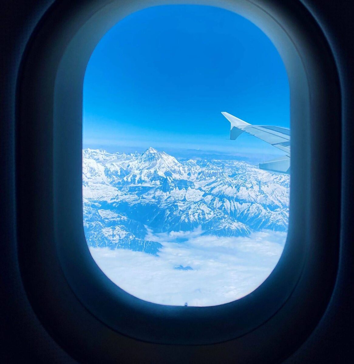 Airplane taking off above Kathmandu valley with the Himalayan foothills in the distance