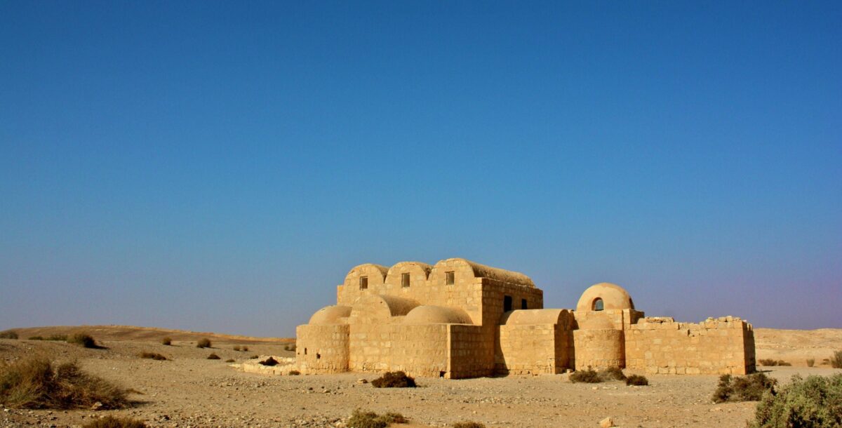 Ancient desert castle in Jordan surrounded by arid landscape and blue sky