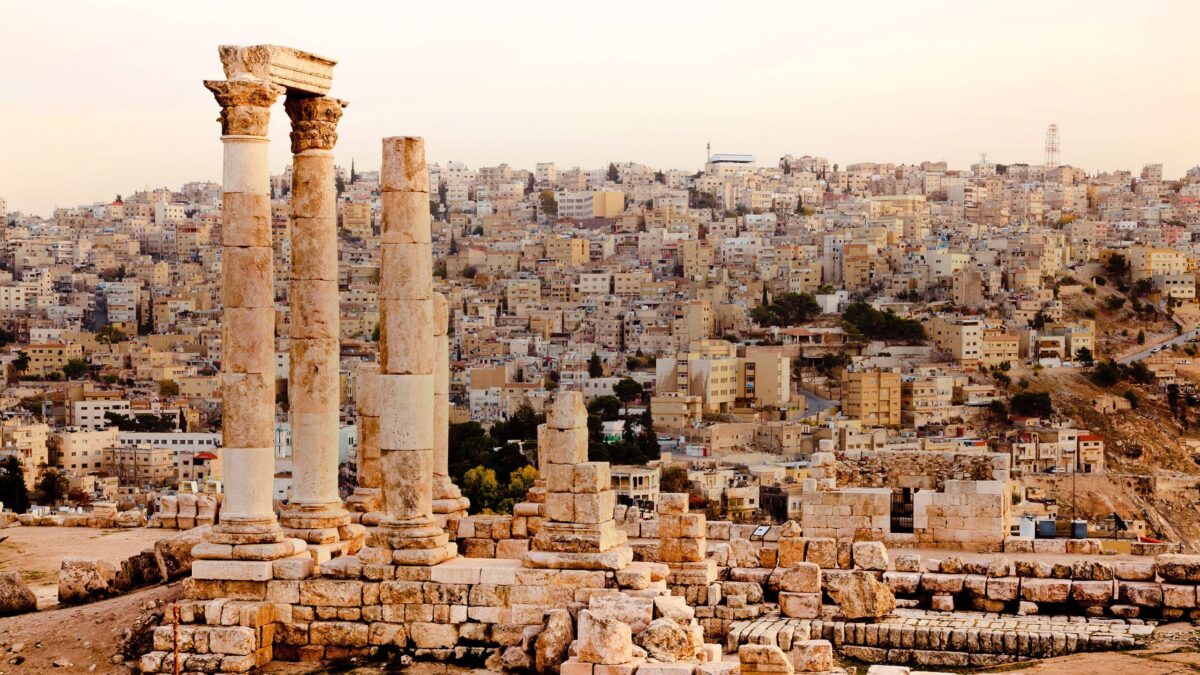 Ancient Roman colonnaded street and ruins under a blue sky in Jerash, Jordan