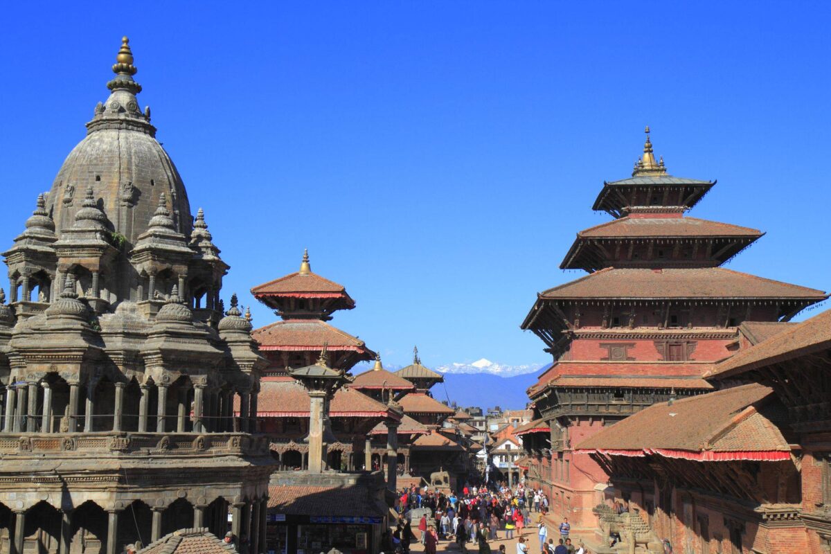 Bouddhanath Stupa in Kathmandu with colorful prayer flags and pilgrims walking around the white dome