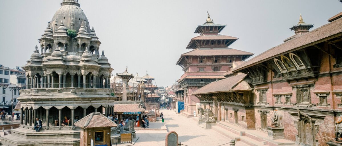 Boudhanath Stupa in Kathmandu with prayer flags and pilgrims circling the white dome under a clear sky