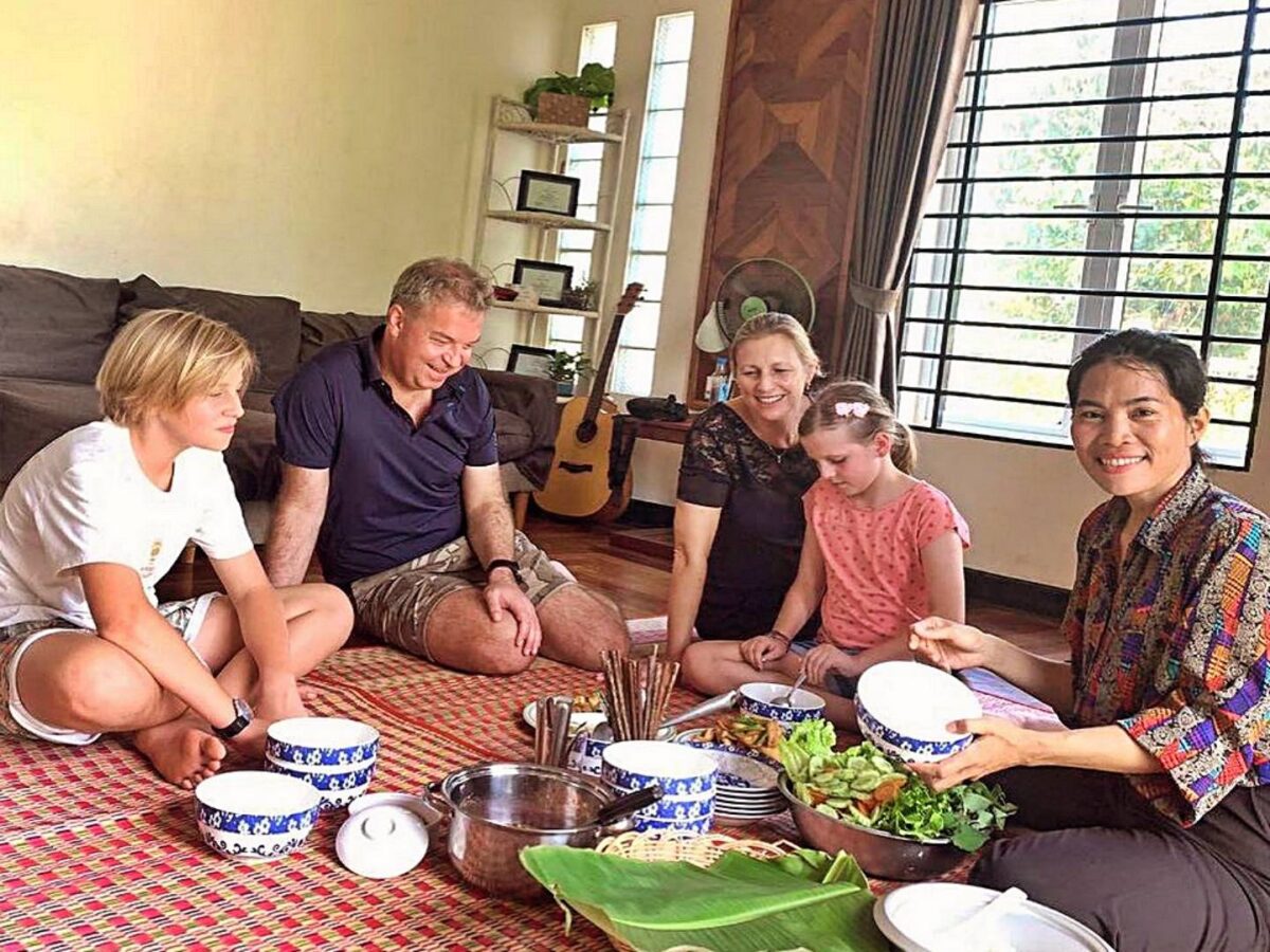 Cambodian circus performer mid-air during an acrobatic act under colorful stage lights at Phare Circus