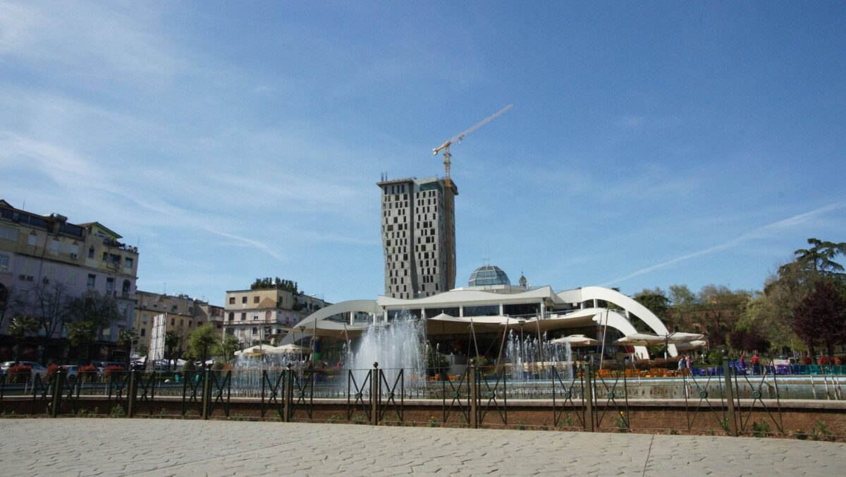 Cityscape of Tirana with colorful buildings and a central square at sunset