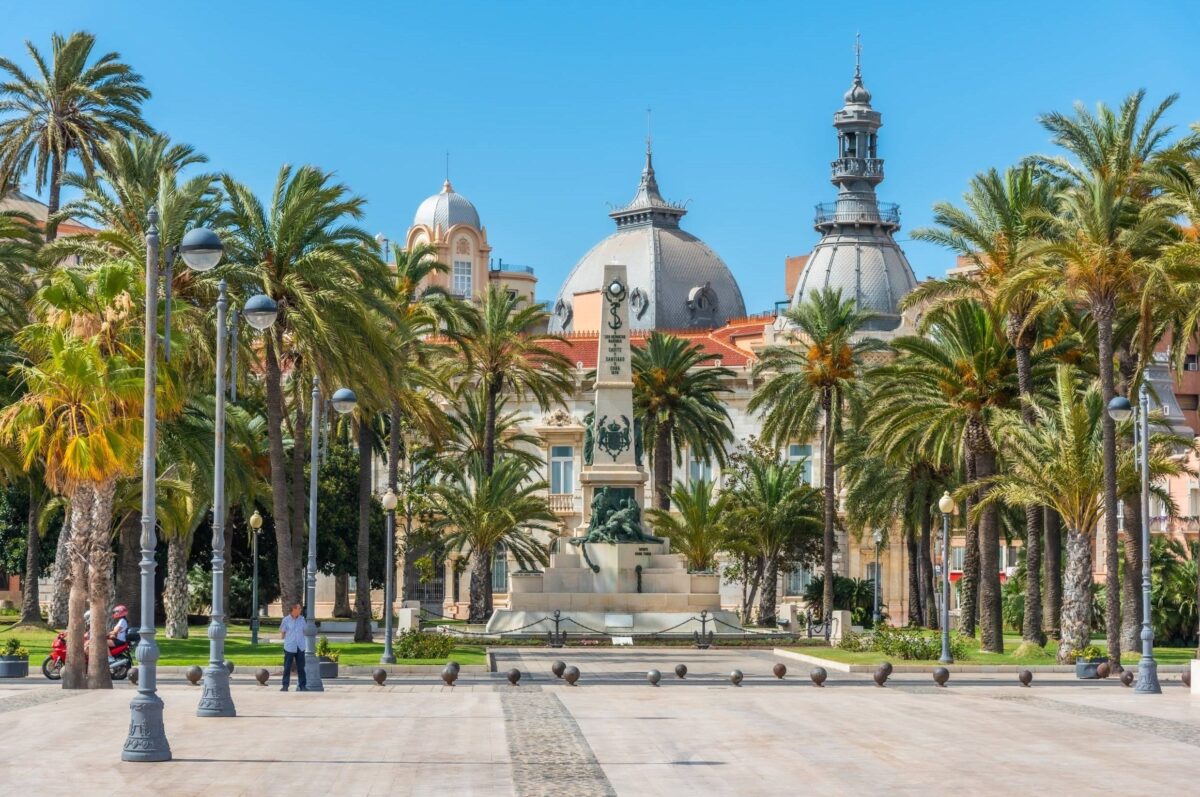 Colorful colonial street in Cartagena’s old town with balconies and flowers in bright sunlight