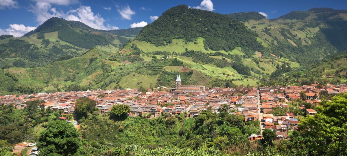 Colorful main square of Jardín with colonial houses, church and mountains in the background