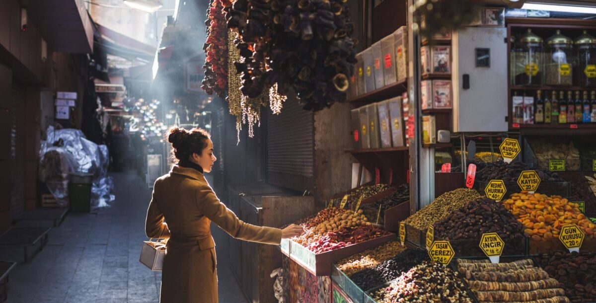 Colorful vaulted alley of Istanbul’s Grand Bazaar with lanterns, carpets and shoppers