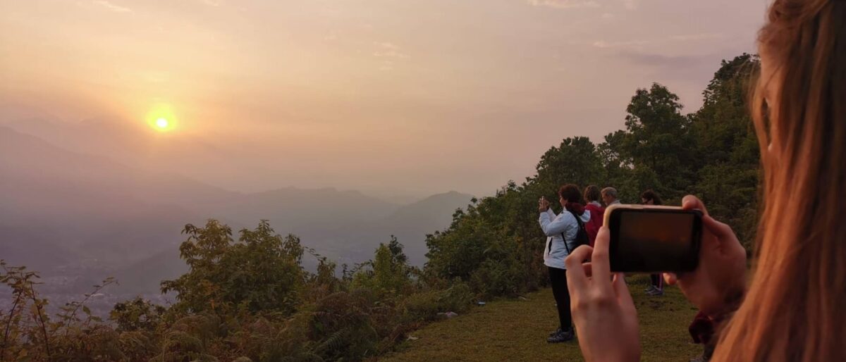 Colorful wooden boats floating on Phewa Lake in Pokhara with the Annapurna range in the distance at sunset