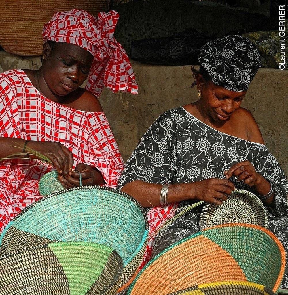 Colorful woven baskets and traditional handicrafts displayed in a Senegalese market near Thiès