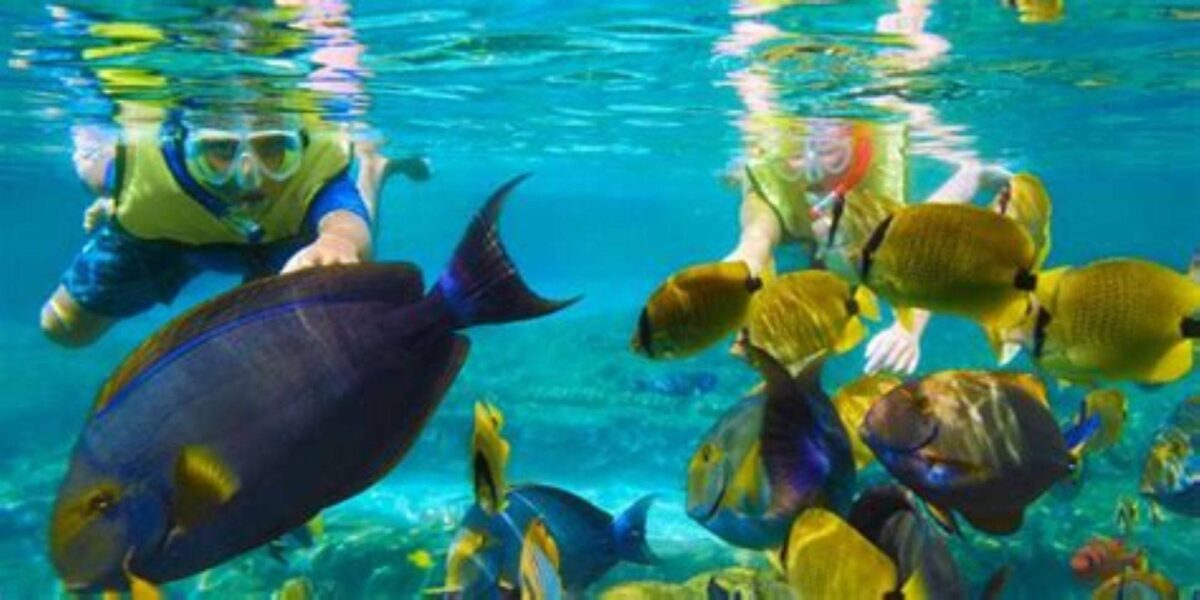 Couple relaxing on sun loungers beside a lagoon in Belle Mare, Mauritius