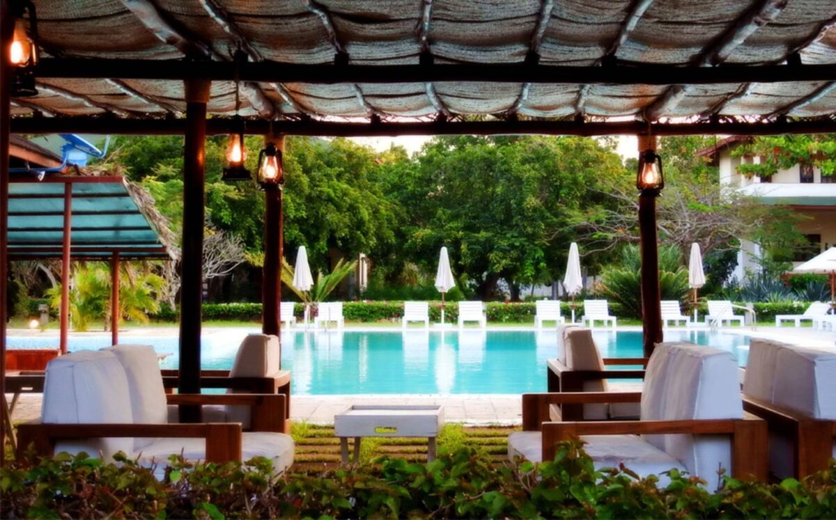 Couple relaxing on sun loungers beside a palm-fringed white-sand beach in Watamu