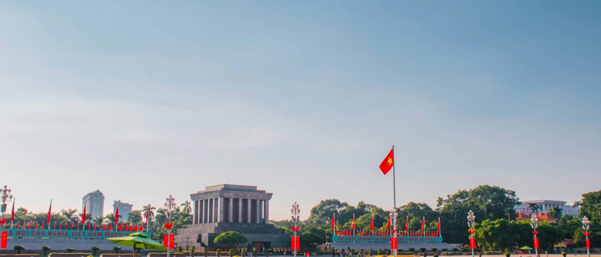 Cyclo rickshaws passing colonial buildings and lakes during a city tour of Hanoi