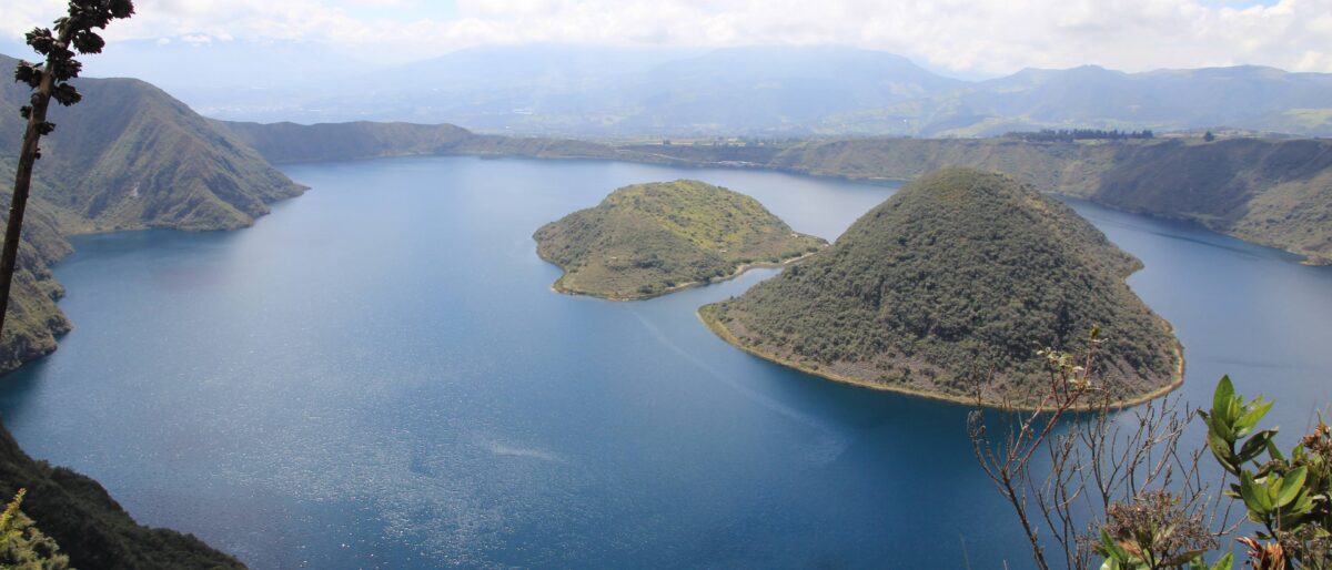 Deep-blue Cuicocha crater lagoon surrounded by green crater walls in the Ecuadorian Andes