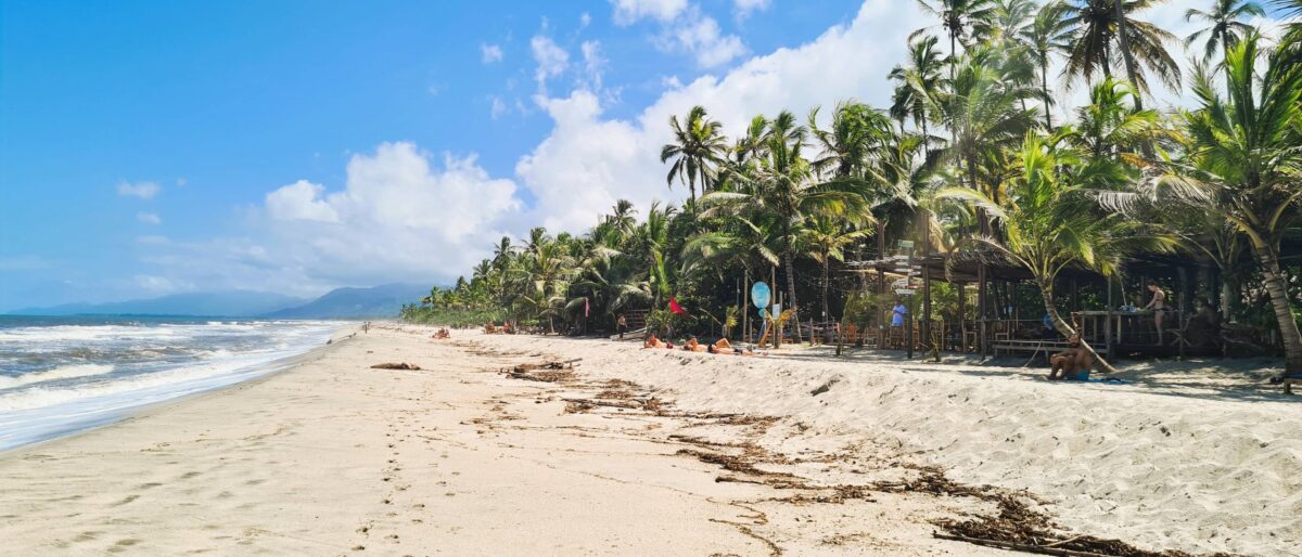 Empty Caribbean beach with hammocks and palm trees near Tayrona in northern Colombia