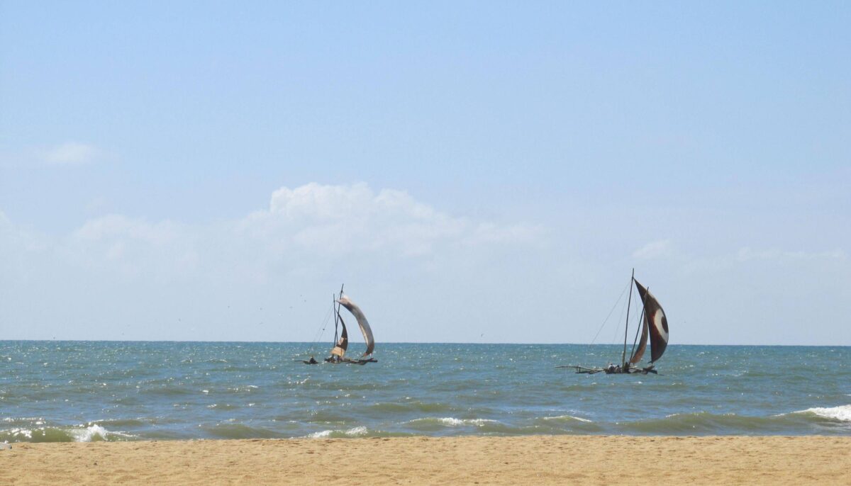 Family enjoying the sandy beach and palm trees at Negombo on the Sri Lankan coast