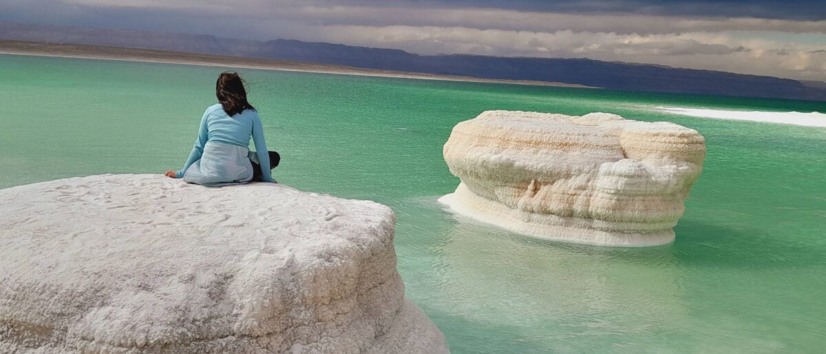 Family floating on their backs in the Dead Sea covered with therapeutic mud