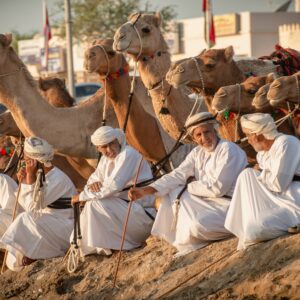 Family-friendly beach resort in Muscat, Oman, with palm-fringed pools and the sea in the background at sunset
