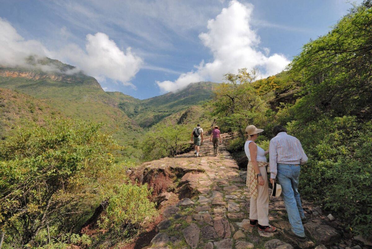 Family hiking along the stone-paved Camino Real between Barichara and Guane with canyon scenery