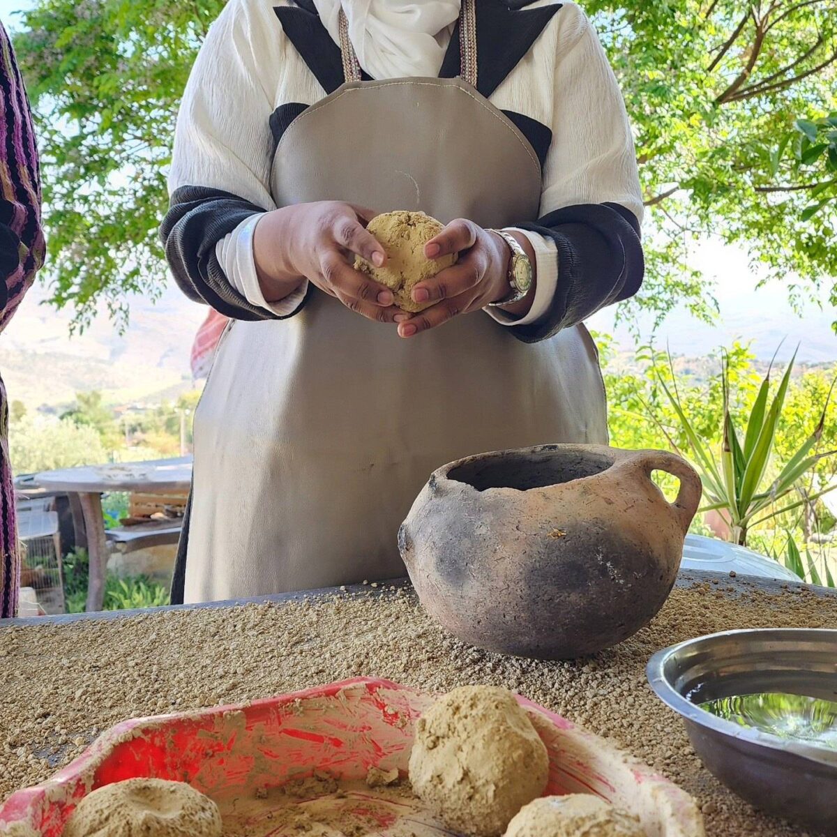 Family walking along a colonnaded Roman street in Jerash, Jordan, under a bright blue sky