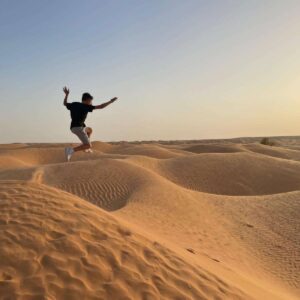 Family walking along a sandy beach at sunset on the island of Djerba in southern Tunisia, with calm sea and warm golden light