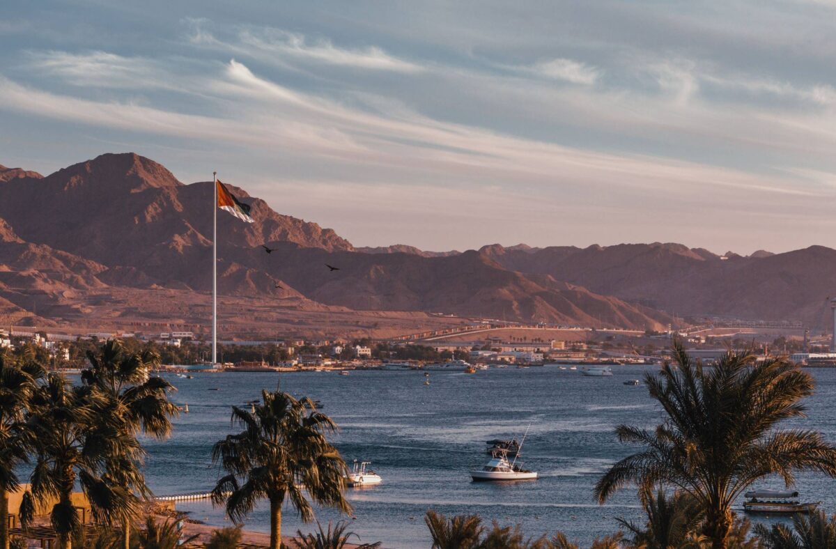 Family walking along the beach in Aqaba at sunset looking out over the Red Sea