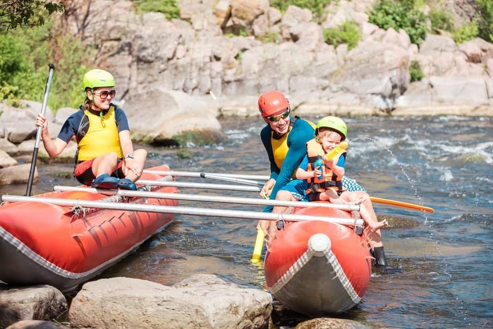 Family white-water rafting on a river in Colombia surrounded by green canyon walls