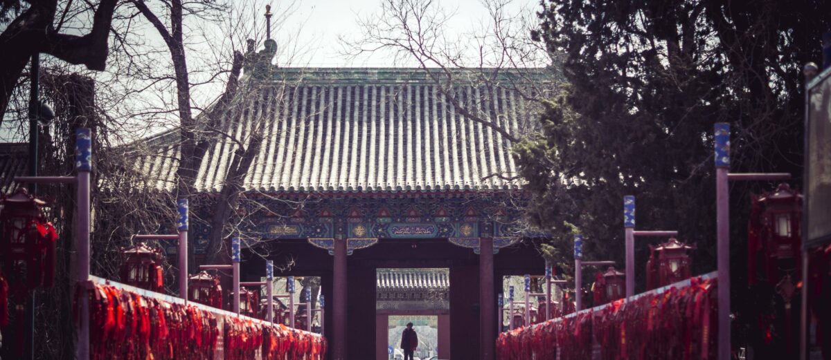 Family with young children walking out of Beijing airport toward the city skyline at sunset