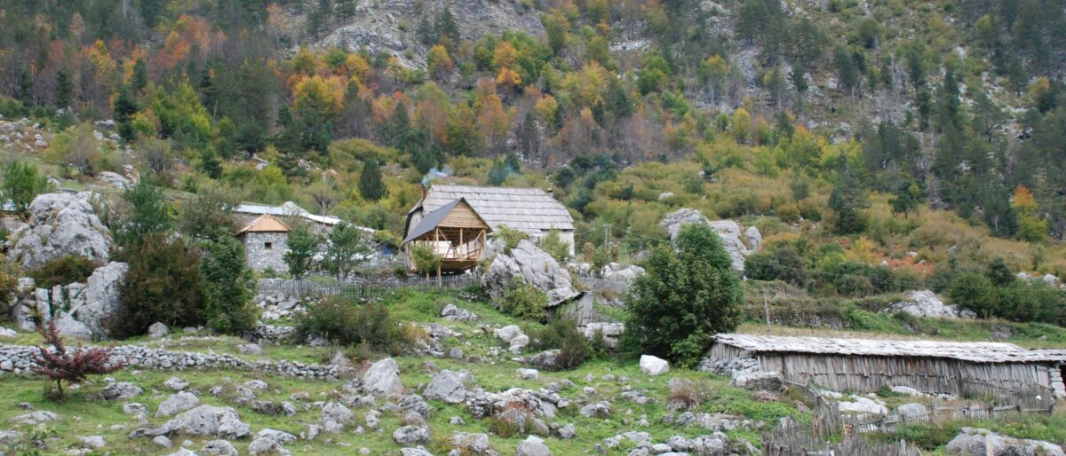 Ferry boat crossing the narrow turquoise waters of Lake Koman surrounded by steep green cliffs in Albania