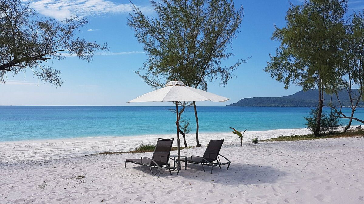 Hammock between palm trees overlooking clear turquoise water and white sand on Koh Rong Samloem