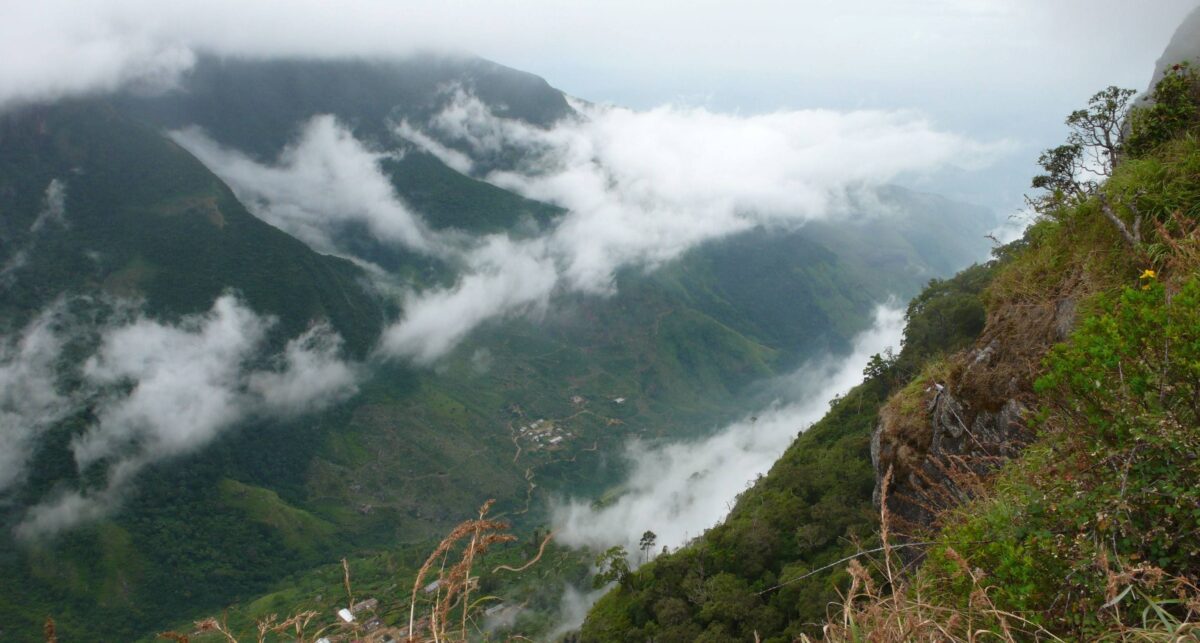 Hiker standing near the edge at World’s End in Horton Plains National Park overlooking steep cliffs and valleys