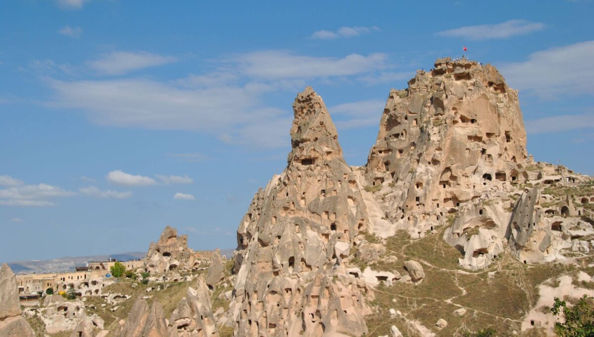 Hikers walking through Cappadocia’s White Valley with tall volcanic pillars and soft rock formations