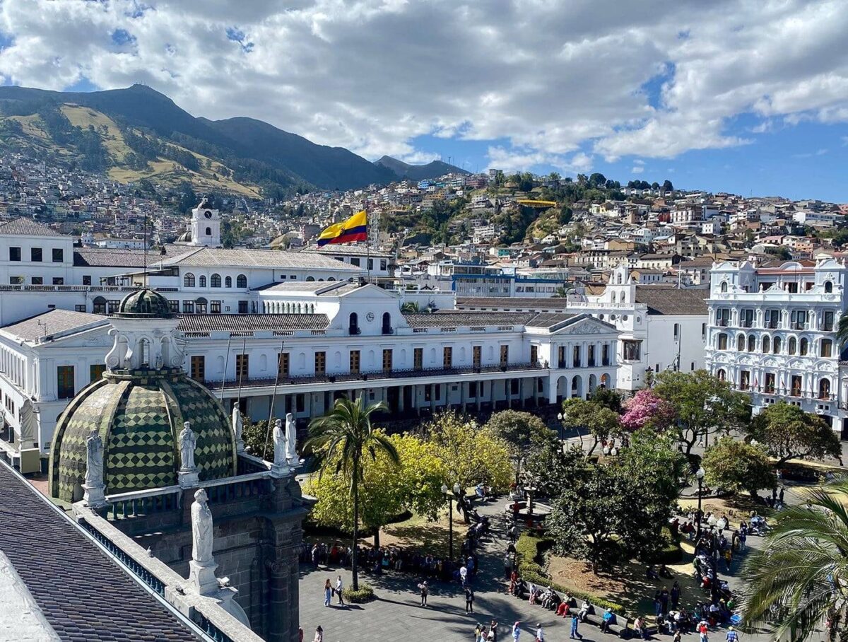 Historic square in Quito’s colonial old town with church façades and people walking