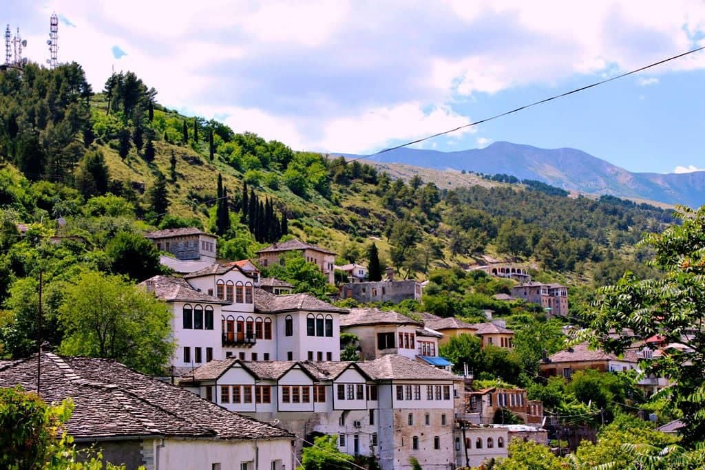 Historic stone houses of Gjirokaster old town climbing a hillside beneath a fortress in southern Albania