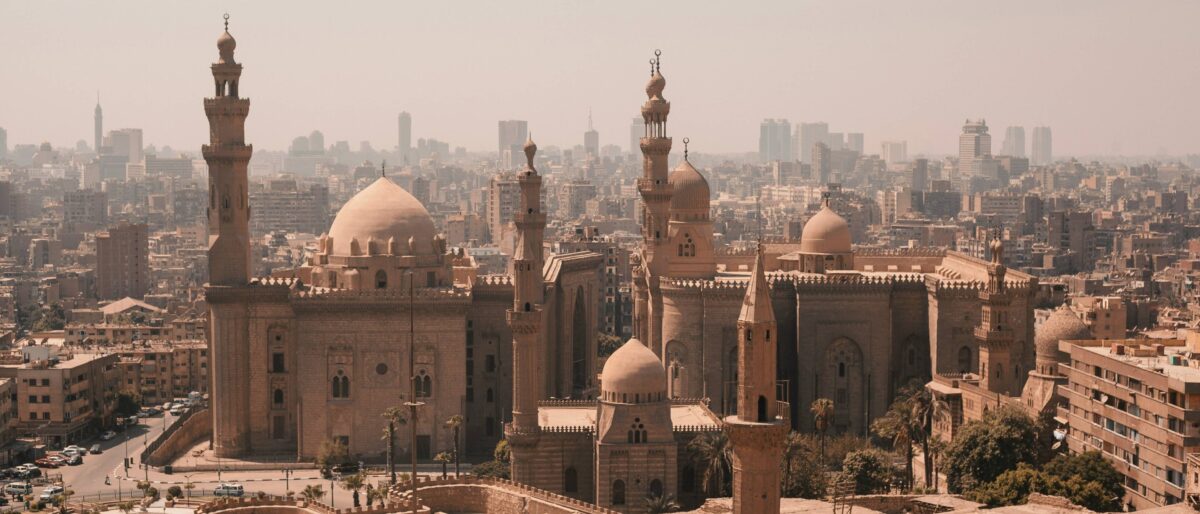 Historic streets and religious buildings in Old Cairo with people walking