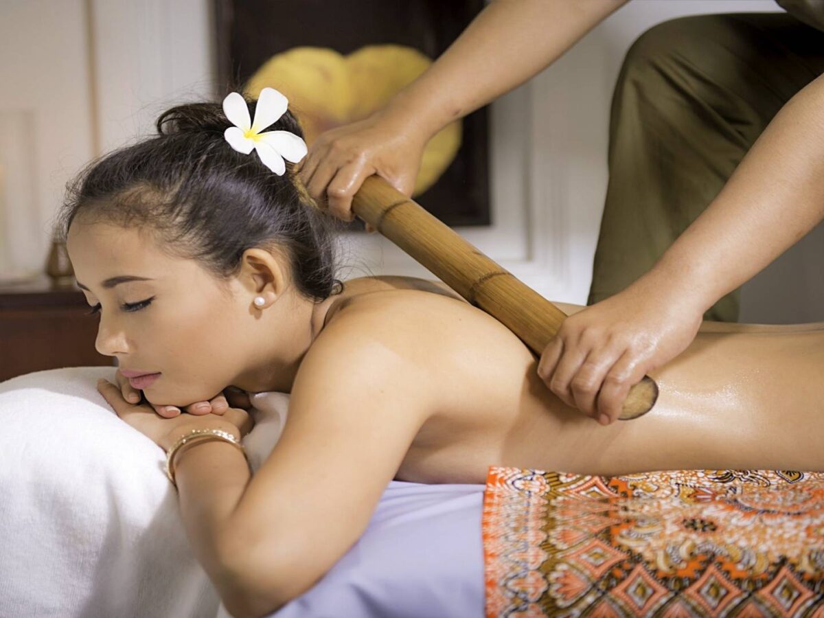 Hot air balloon rising over the treetops near Angkor temples at sunset in Siem Reap
