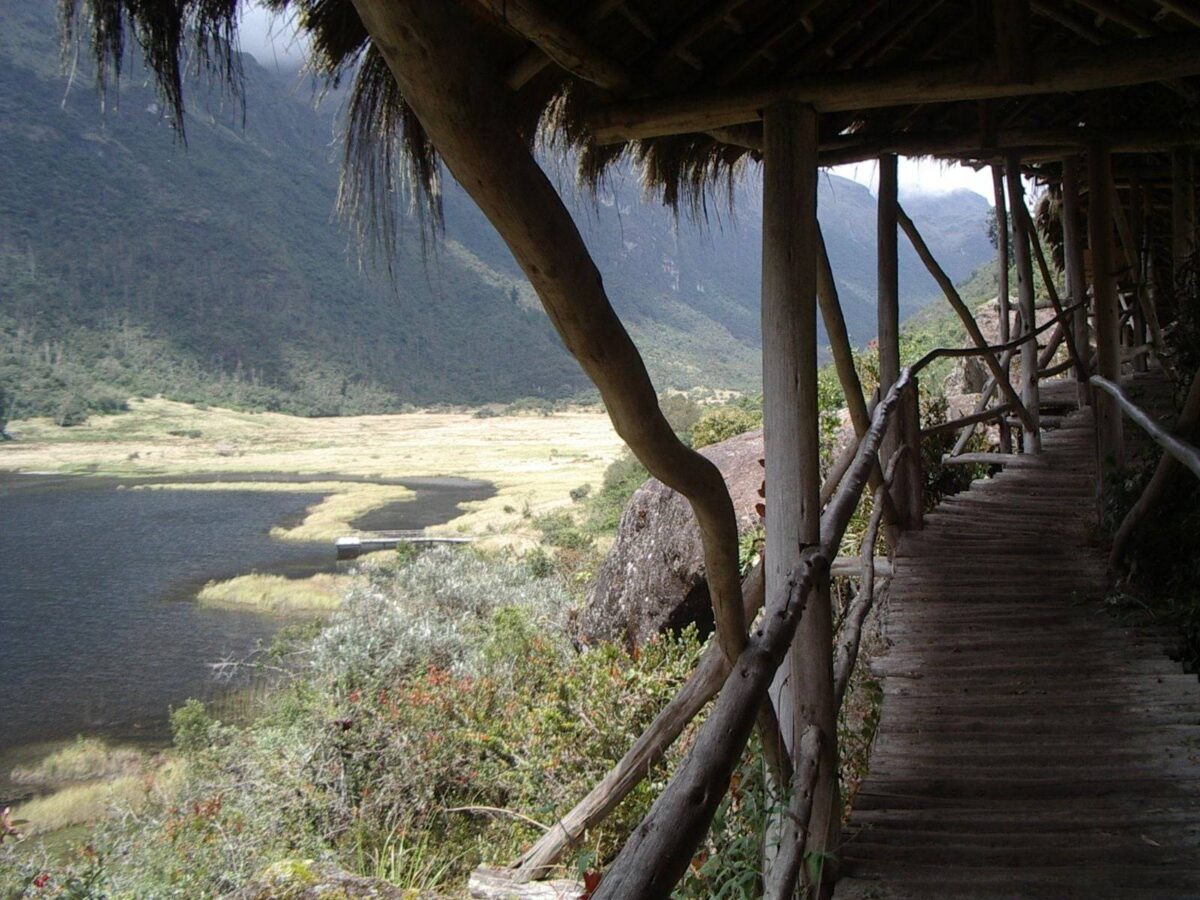 Lagoon and rolling páramo hills in Cajas National Park under a dramatic cloudy sky