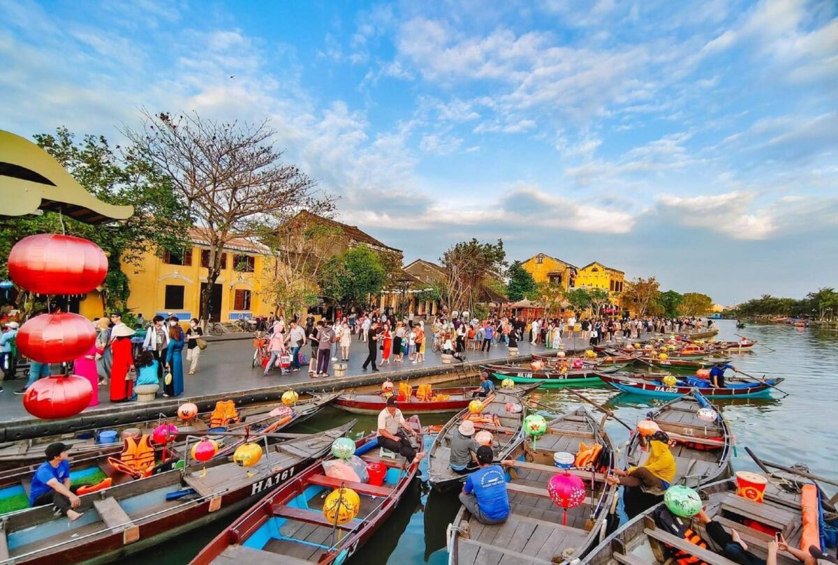 Lantern-lit riverside scene in Hoi An ancient town at dusk with reflections on the water