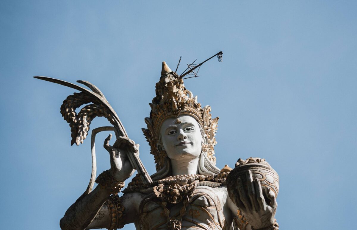 Lush rice terraces and palm trees surrounding traditional buildings near Ubud, Bali
