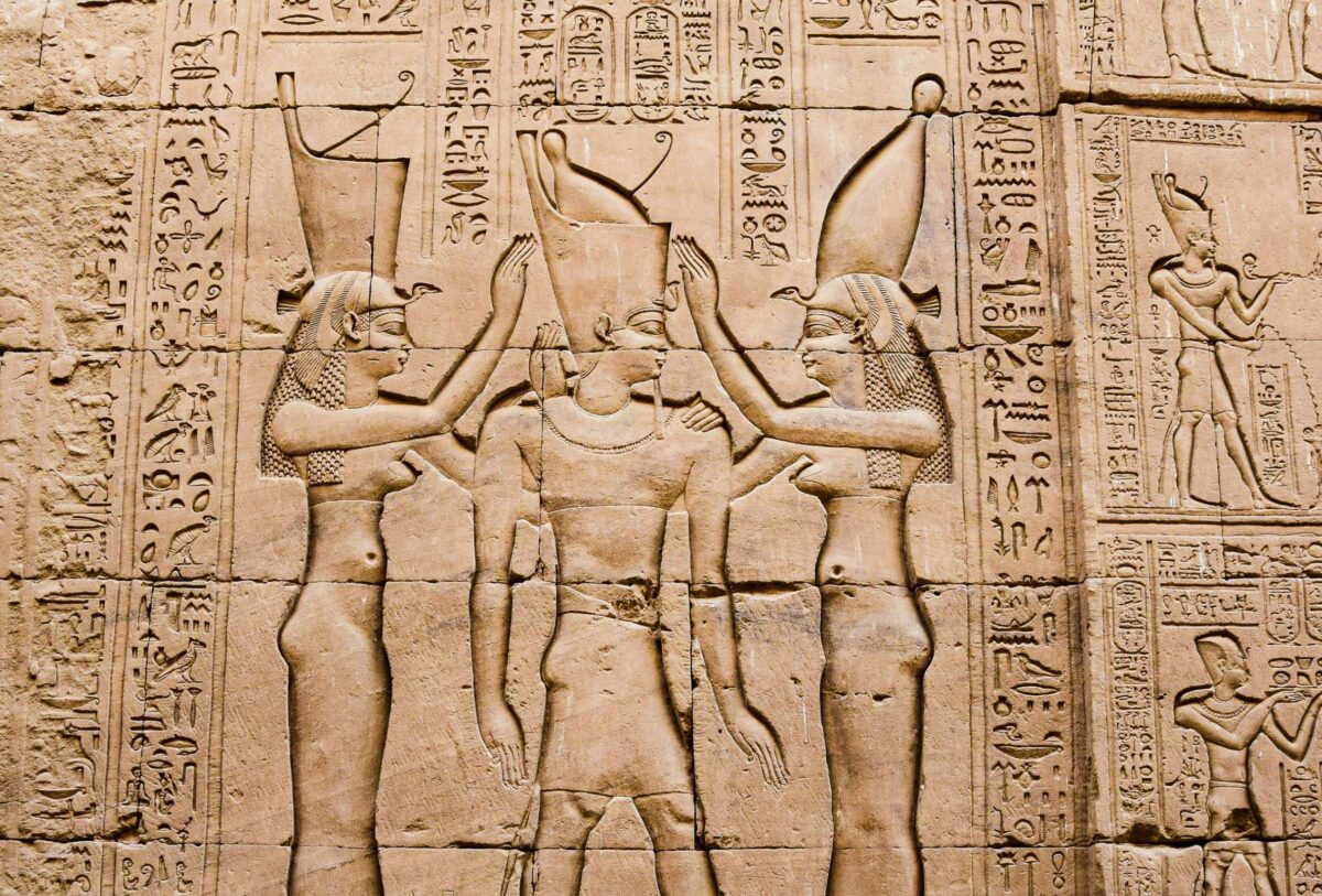 Massive sandstone pylons and statues at Edfu Temple under bright sunlight