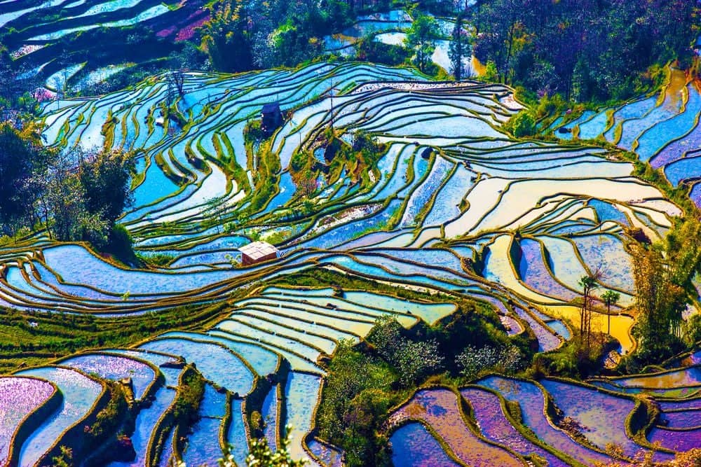 Mountain landscape near Lijiang in Yunnan with traditional village and terraced fields under a clear sky