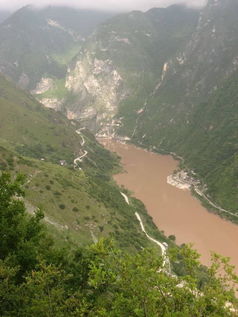 Narrow trail high above the river inside Tiger Leaping Gorge with steep cliffs on both sides
