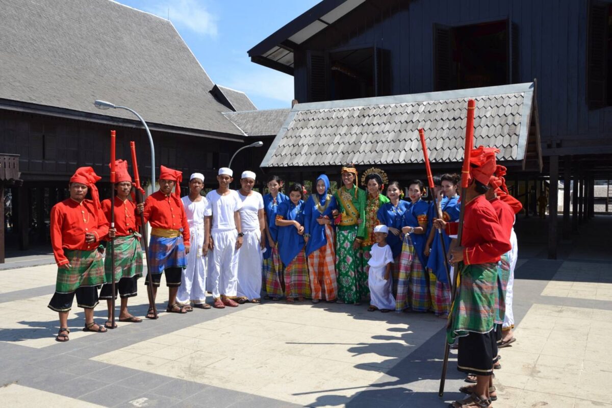 Night arrival scene at Makassar airport with travelers exiting the terminal and city lights in the background