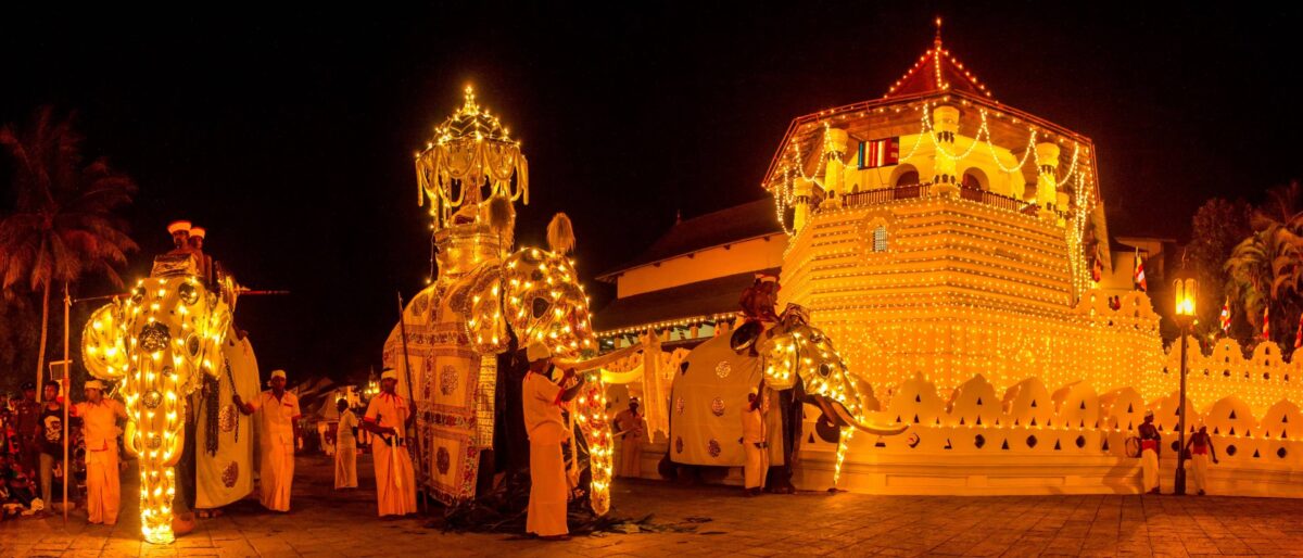 Night-time Kandy Perahera procession with a richly decorated elephant and traditional Sri Lankan dancers carrying torches
