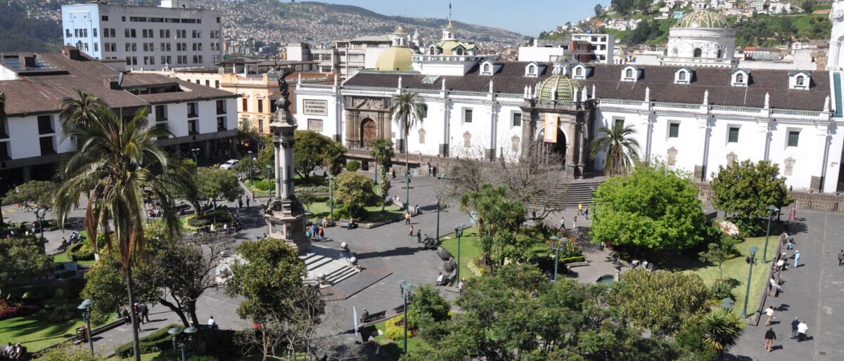 Night view over the illuminated historic center of Quito nestled between Andean hills