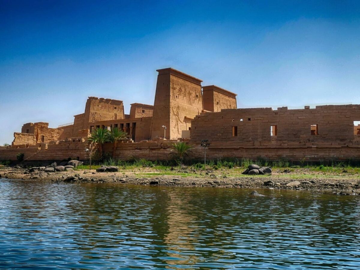 Nile cruise boat docked near the riverbank in Aswan with desert hills in the background