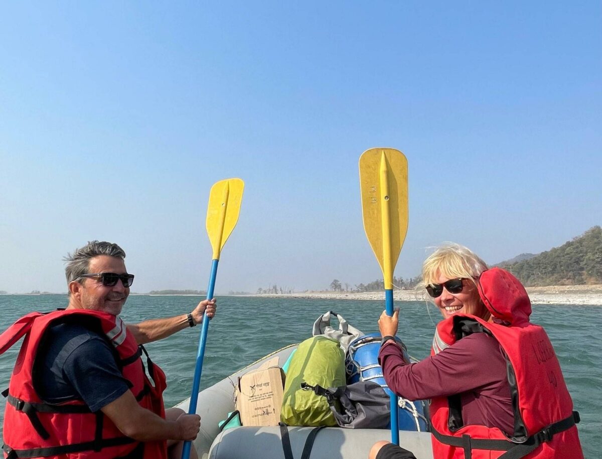 Open-top jeep on safari track in Bardia National Park heading towards a watchtower overlooking grassy plains