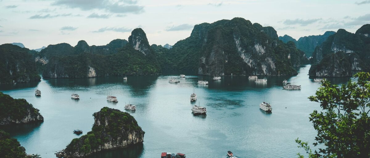 Overnight cruise ship anchored among limestone karsts in Ha Long Bay at sunset