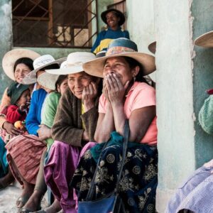 Panoramic view of Bolivia’s Uyuni Salt Flats under a blue sky with distant mountains and 4x4 vehicles crossing the white salt crust